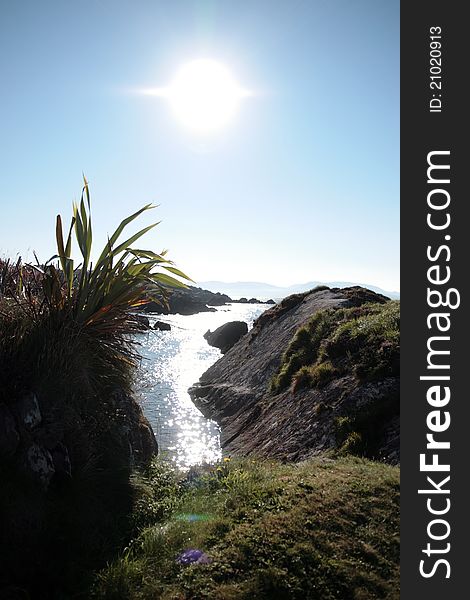 Scenic view in kerry ireland of rocks and sea with mountains against a beautiful bright sunny sky. Scenic view in kerry ireland of rocks and sea with mountains against a beautiful bright sunny sky