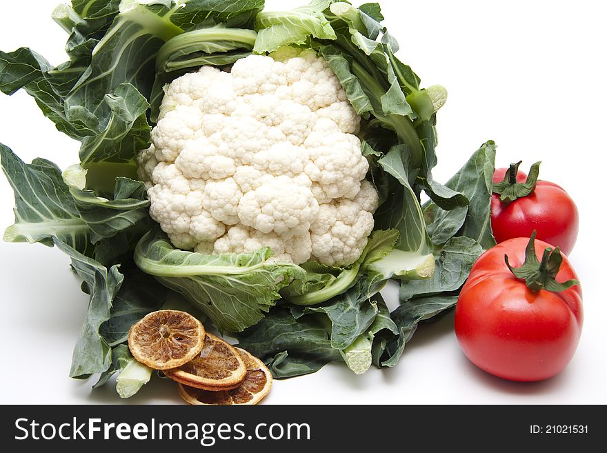 Cauliflower with tomatoes and lemon on white background