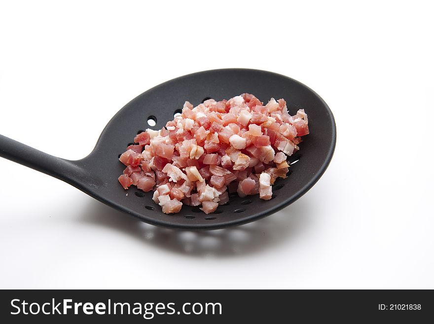 Bacon bits on black plastic soup ladle