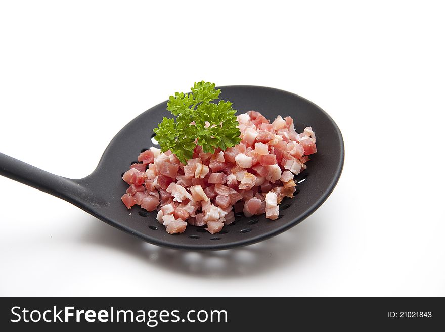 Bacon bits on black plastic soup ladle. Bacon bits on black plastic soup ladle