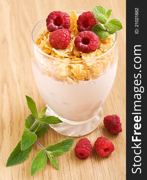 Glass of Raspberry yogurt with flakes and fresh raspberries