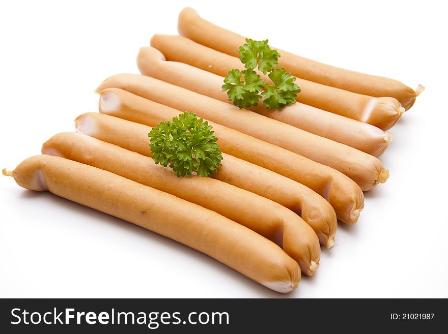 Raw frankfurter with parsley on white background