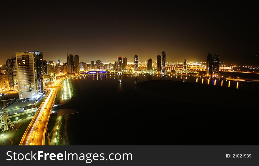 Night view of Al-Khan lake in Sharjah. Surrounding view high rise buildings reflected on the waters. Dubai is visible in the backround. Night view of Al-Khan lake in Sharjah. Surrounding view high rise buildings reflected on the waters. Dubai is visible in the backround