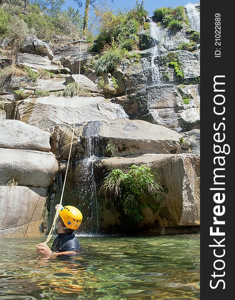 Men in the water pulling the rapel rope after descending. Men in the water pulling the rapel rope after descending