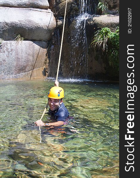 Men in the water pulling the rapel rope after descending. Men in the water pulling the rapel rope after descending