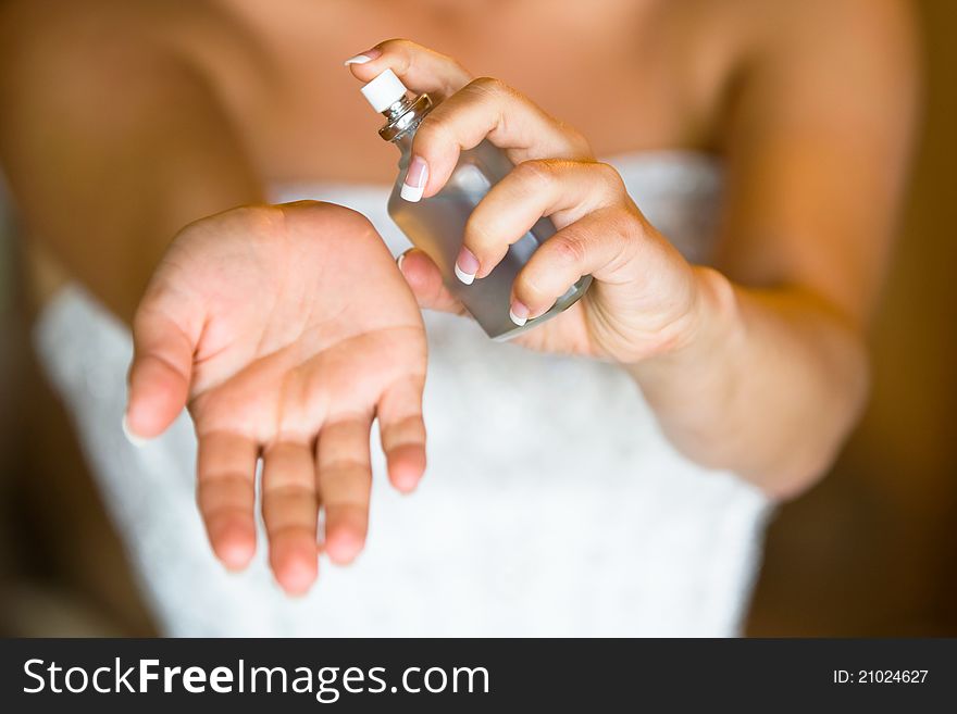 A woman spraying perfume on her wrist. A woman spraying perfume on her wrist