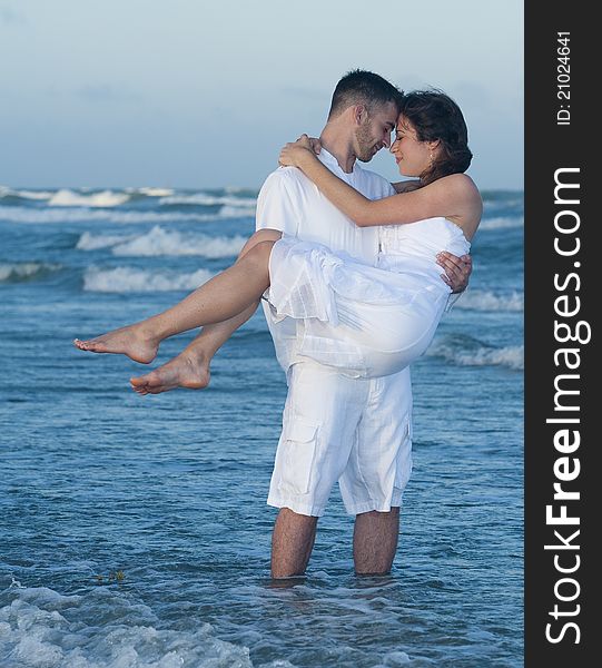 Man holding women in his arms on beach. Man holding women in his arms on beach