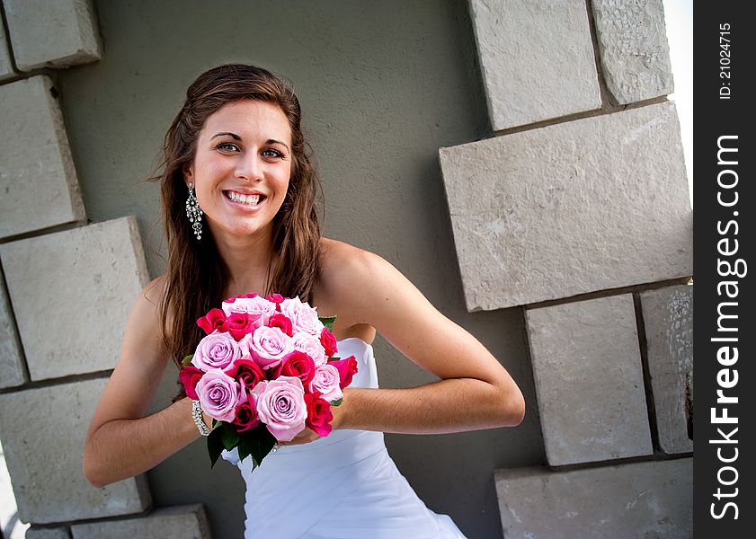 Bride smiling, outdoors against wall. Bride smiling, outdoors against wall