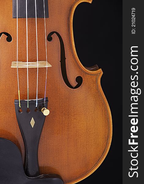 A violin viola body up close isolated against a black background. A violin viola body up close isolated against a black background