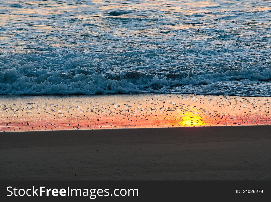 The sunset reflecting on wet sand on the beach. The sunset reflecting on wet sand on the beach