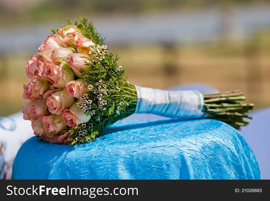 A wedding bouquet of roses lying on a table outdoors