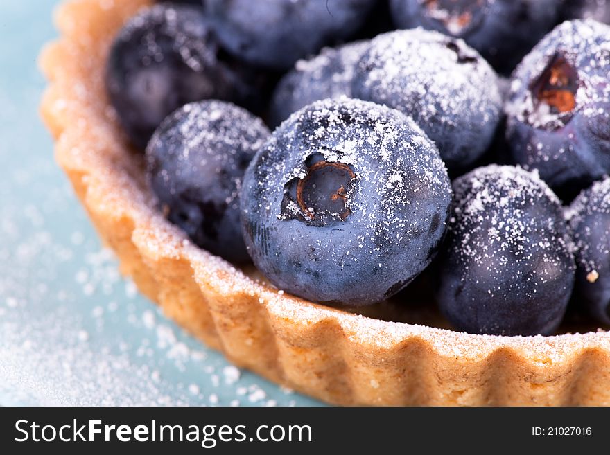 Macro picture of blueberries tart on blue background