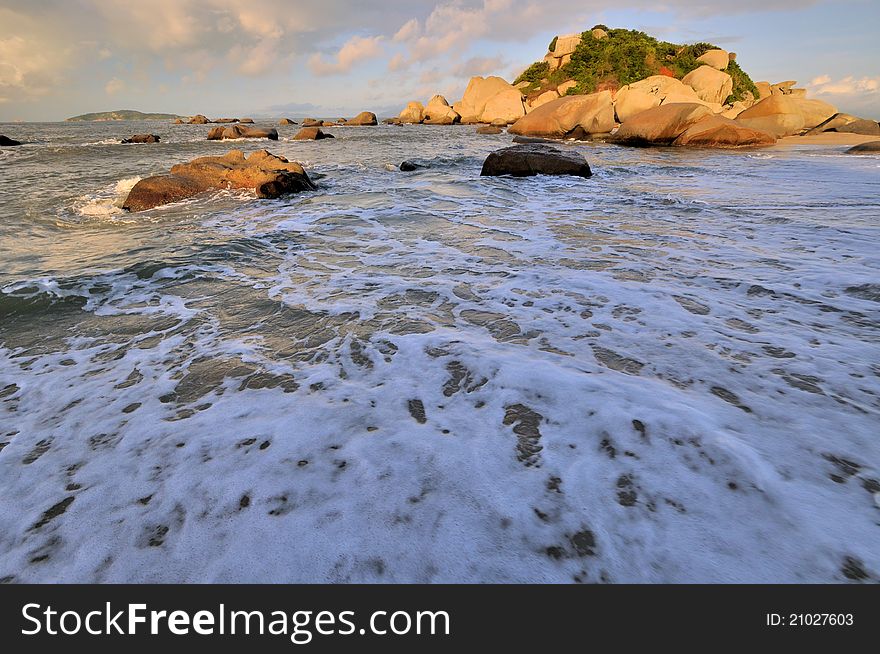 Wide sea beach with rock in sunrise