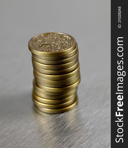 Australian dollar coins stacked and against a silver background