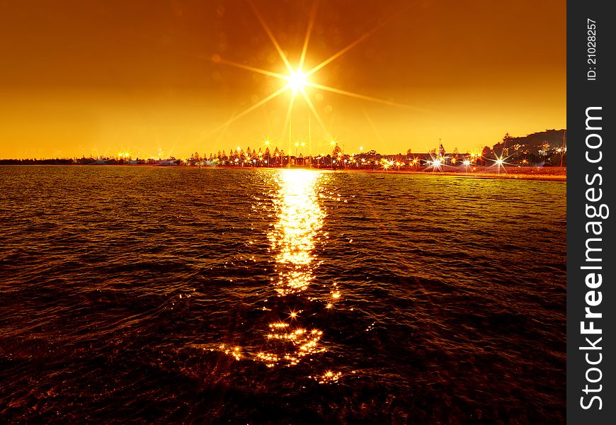 Sunset over the sea with street light background