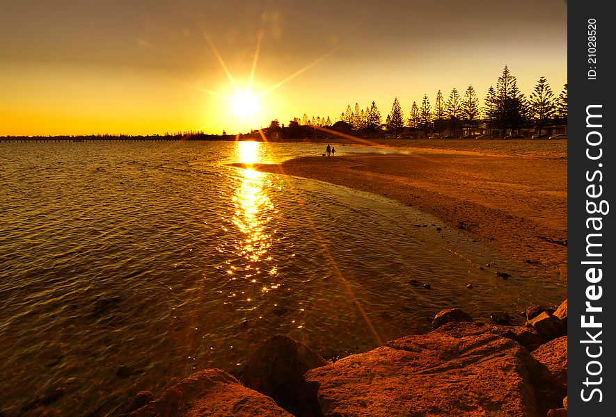 Bright red sunset over water on beach