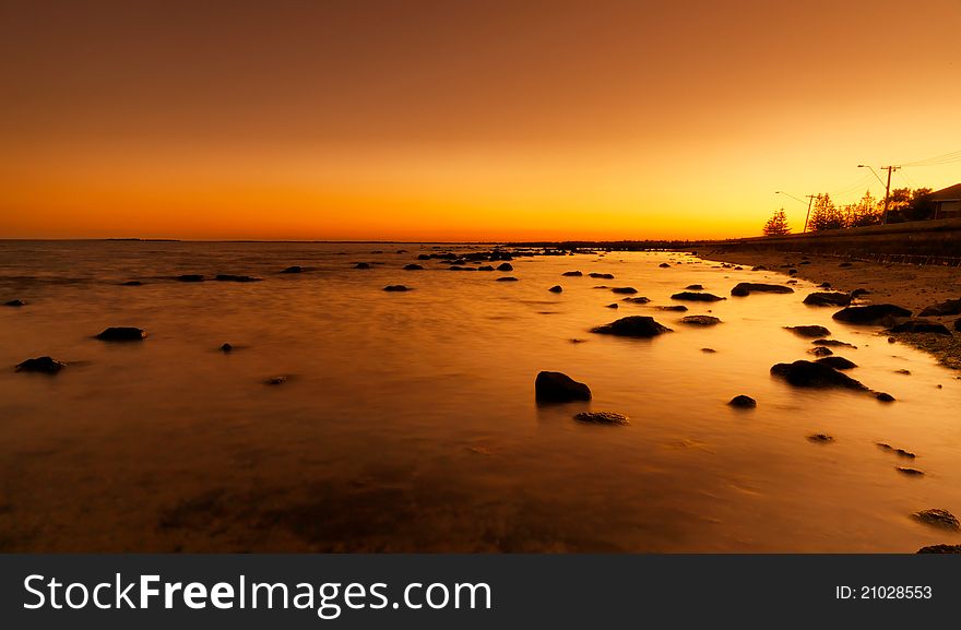 Bright red sunset over water on beach