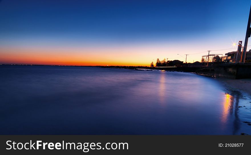 Bright blue sunset over water on beach with