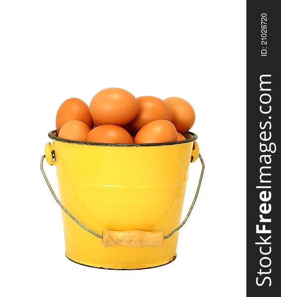 Eggs in yellow old metal bucket isolated on white