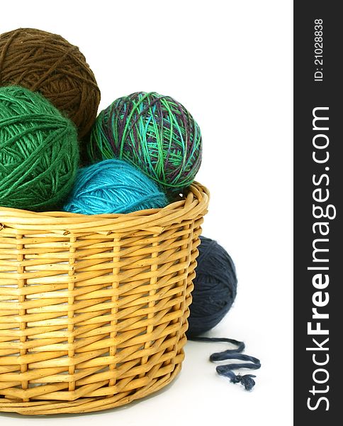 Wool balls in a wattled basket on white background. Wool balls in a wattled basket on white background