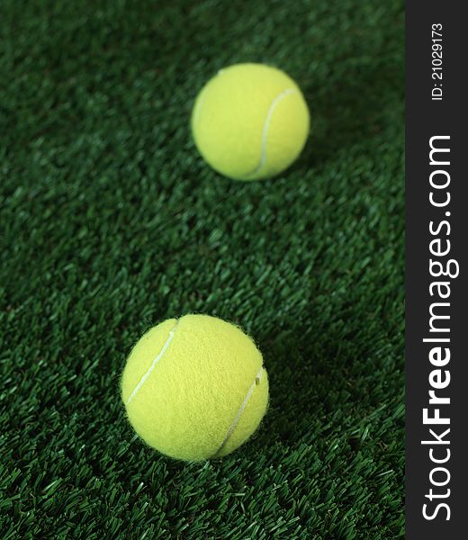 Sporting tennis balls on artificial green grass