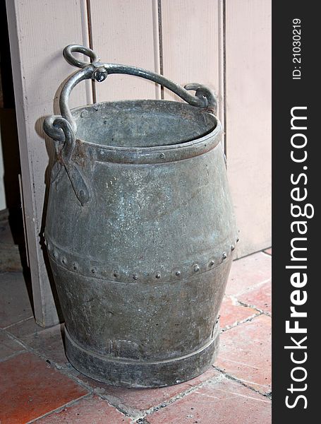 A Vintage Metal Bucket Being Used as a Doorstop. A Vintage Metal Bucket Being Used as a Doorstop.