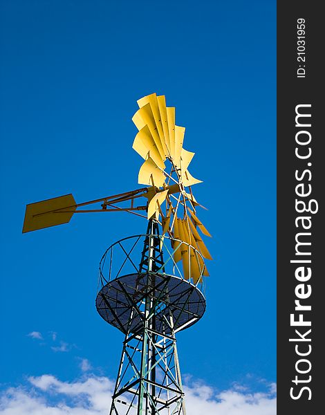 Yellow windmill and blue sky with clouds behind it. Yellow windmill and blue sky with clouds behind it