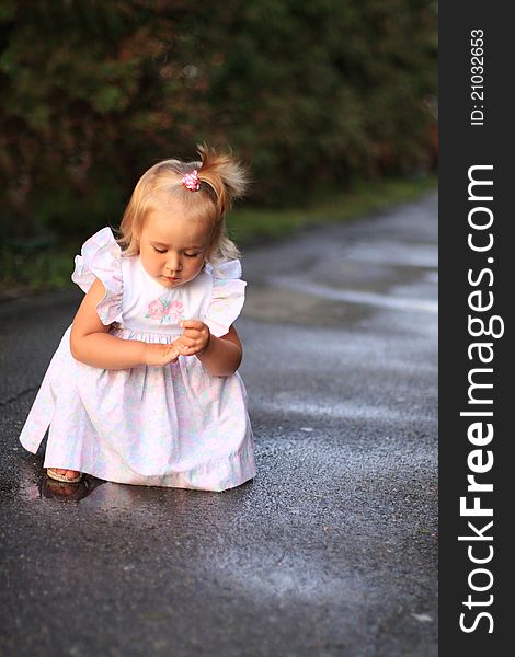 Portrait of the little girl walking outdoors after rain