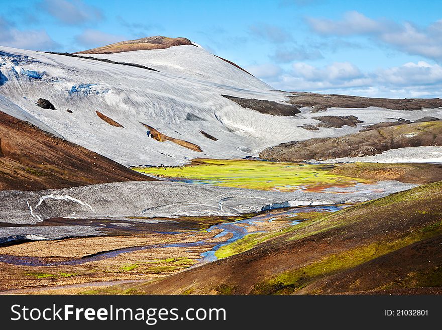 Majestic Mountain landscape in green wally with crystal river. Iceland