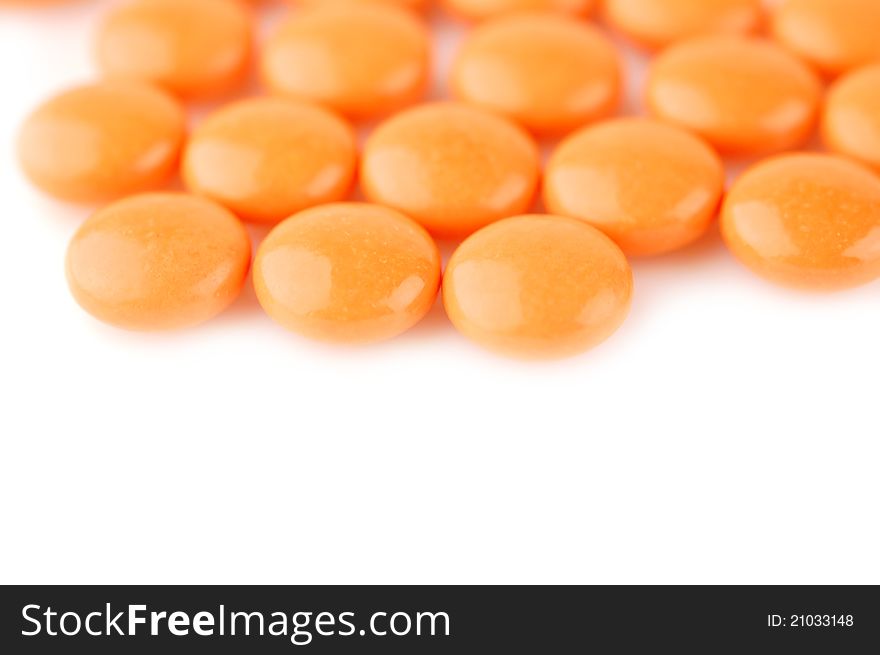 Orange tablets on a white background. Selective focus. Orange tablets on a white background. Selective focus.