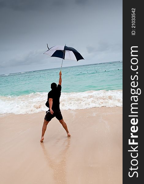 Tanned Man Jump With Umbrella In Blue Sea