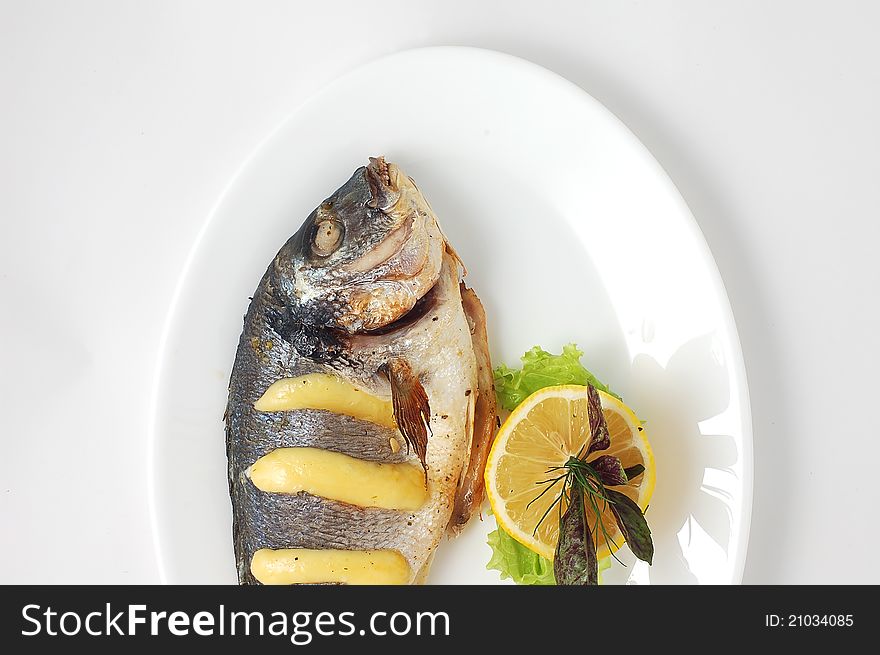 Smoked fish with a lemon, the top view on a white background, close up. Smoked fish with a lemon, the top view on a white background, close up.