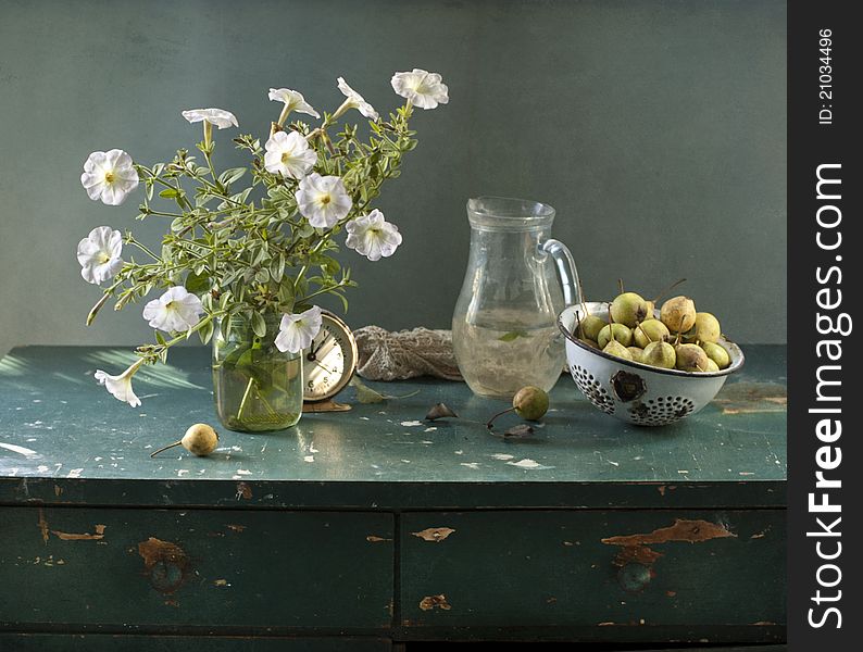 Still life with a petunia and pears on a table