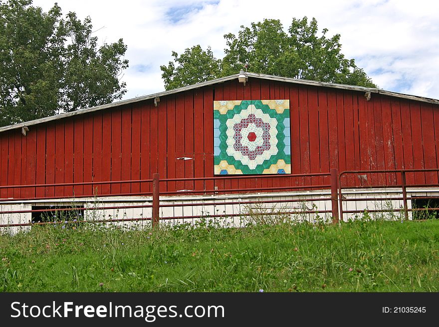 A barn with a quilt square over the door. A barn with a quilt square over the door