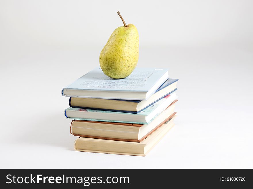 Fruit on books on simple background