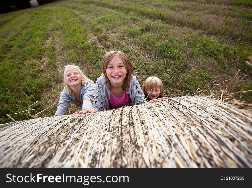 Three kids with bale of hay. Three kids with bale of hay