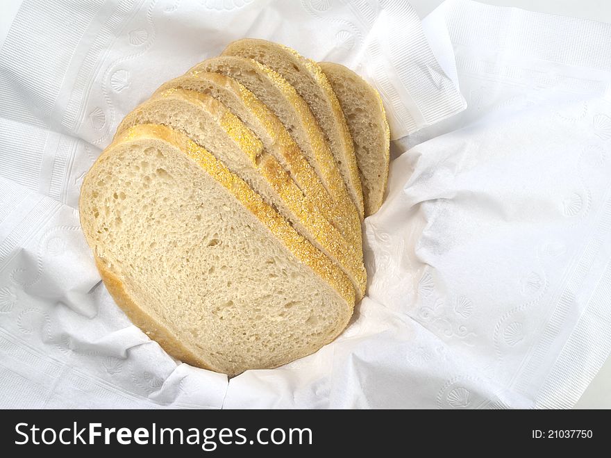 Fresh half loaf of sour dough bread is spread out in paper napkin. Fresh half loaf of sour dough bread is spread out in paper napkin.