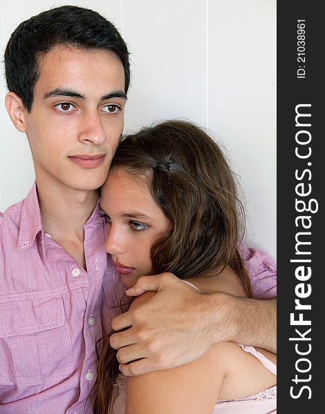 A simple portrait of a cute young couple cuddling, with the men's arm around the women's shoulder. A simple portrait of a cute young couple cuddling, with the men's arm around the women's shoulder.