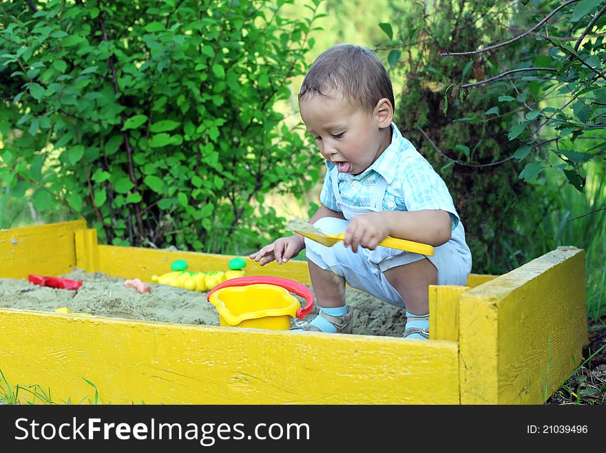 Baby plays with toys in sandbox. Baby plays with toys in sandbox