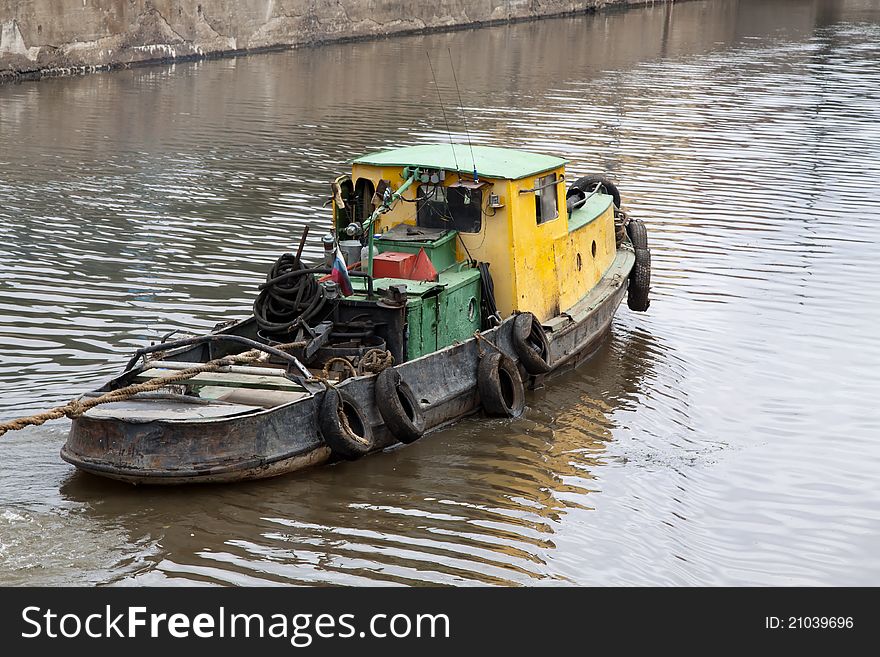 Yellow old tugboat on water