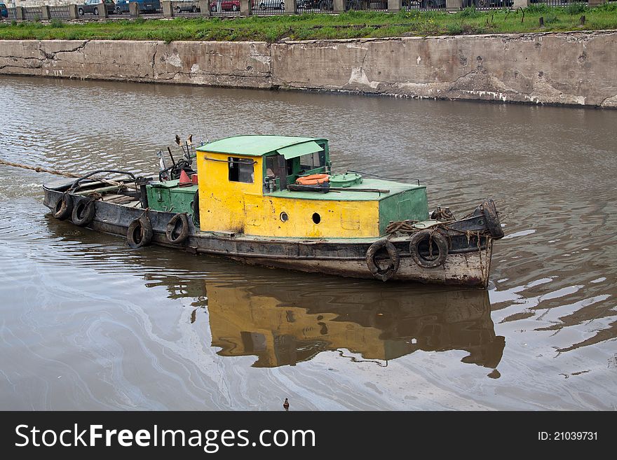 Yellow old tugboat on water