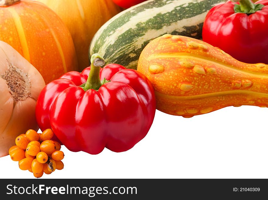 Autumn still-life filled with vitamins from red paprika, pumpkin, vegetable marrows and ripe sea-buckthorn berries on isolated white background. Autumn still-life filled with vitamins from red paprika, pumpkin, vegetable marrows and ripe sea-buckthorn berries on isolated white background