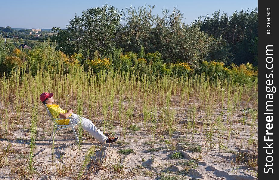 Man Sitting In A Field Enjoying The Nature