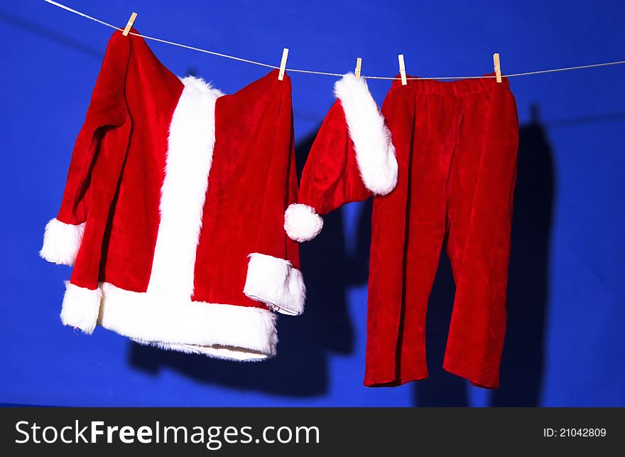 Santa's outfit hanging against blue background. Santa's outfit hanging against blue background