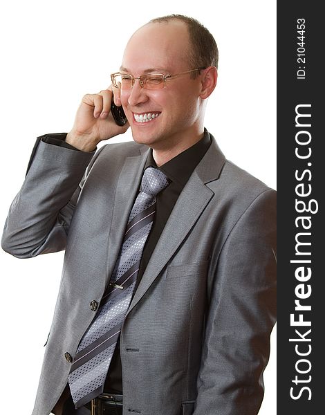 Young man in business suit, tie, glasses laughing and talking on a cell phone on a white background. Young man in business suit, tie, glasses laughing and talking on a cell phone on a white background