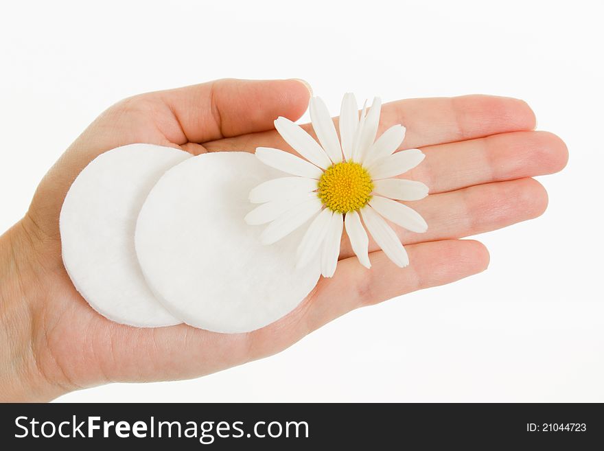 Cosmetic drives and daisy flower on a female palm on a white background. Cosmetic drives and daisy flower on a female palm on a white background.