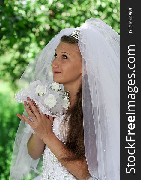 The bride with a bouquet on a green background. The bride with a bouquet on a green background