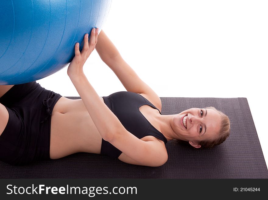 A young woman is doing exercises with a blue ball. A young woman is doing exercises with a blue ball