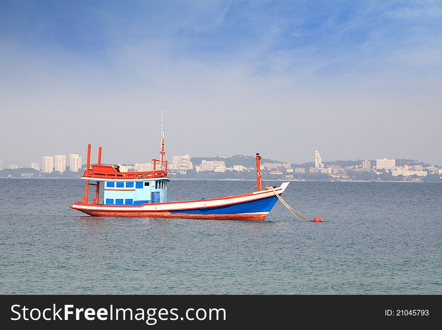 Fishing boat in wide ocean near city