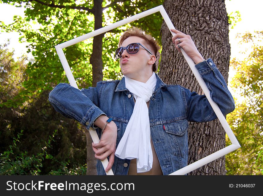 Young human on the green grass with white frame, he has blue goggles and jean jacket and white scarf he is funny. Young human on the green grass with white frame, he has blue goggles and jean jacket and white scarf he is funny